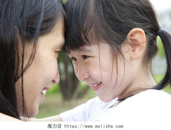 小女孩和妈妈微笑碰头抵着头注视对视母亲节